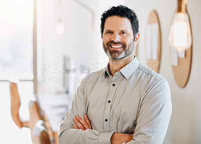 Buy stock photo Shot of a mature businessman standing alone in the office with his arms folded