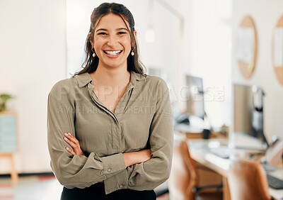 Buy stock photo Shot of an attractive young businesswoman standing alone in the office with her arms folded