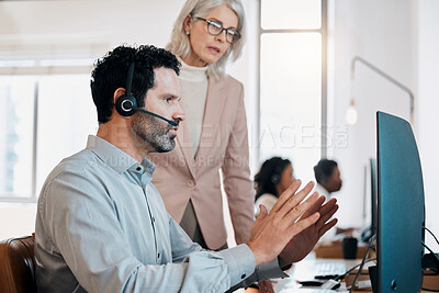 Buy stock photo Shot of a mature agent sitting in the office and using his computer while talking to his manager