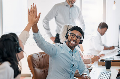 Buy stock photo Shot of a handsome young agent sitting and giving his colleague a high five in the office