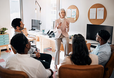 Buy stock photo Shot of a mature businesswoman sitting and training her team in the office