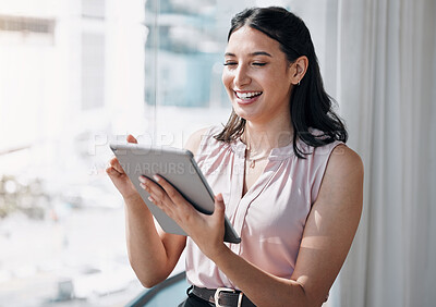 Buy stock photo Shot of an attractive young businesswoman standing alone in the office and using a digital tablet