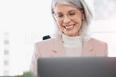 Buy stock photo Shot of a mature businesswoman sitting alone in the office and using her laptop