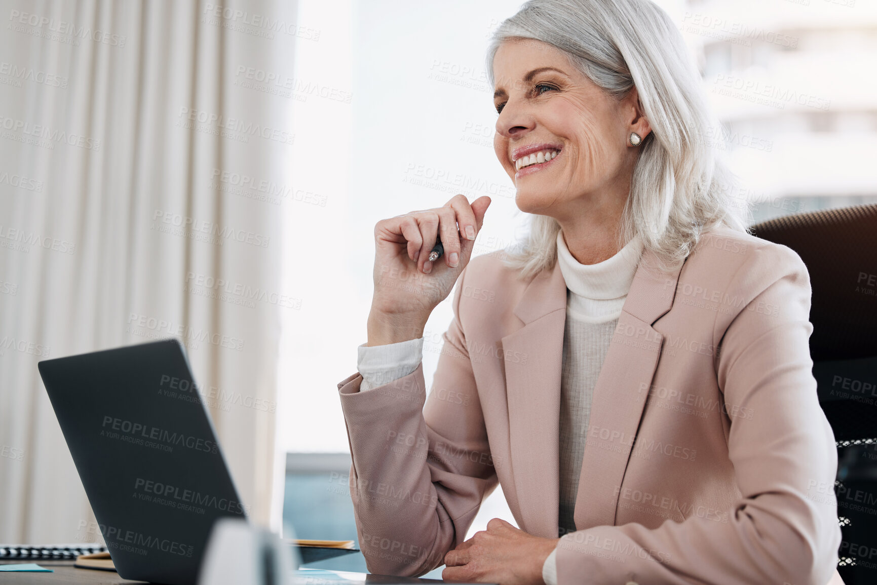 Buy stock photo Shot of a mature businesswoman sitting alone in the office and using her laptop