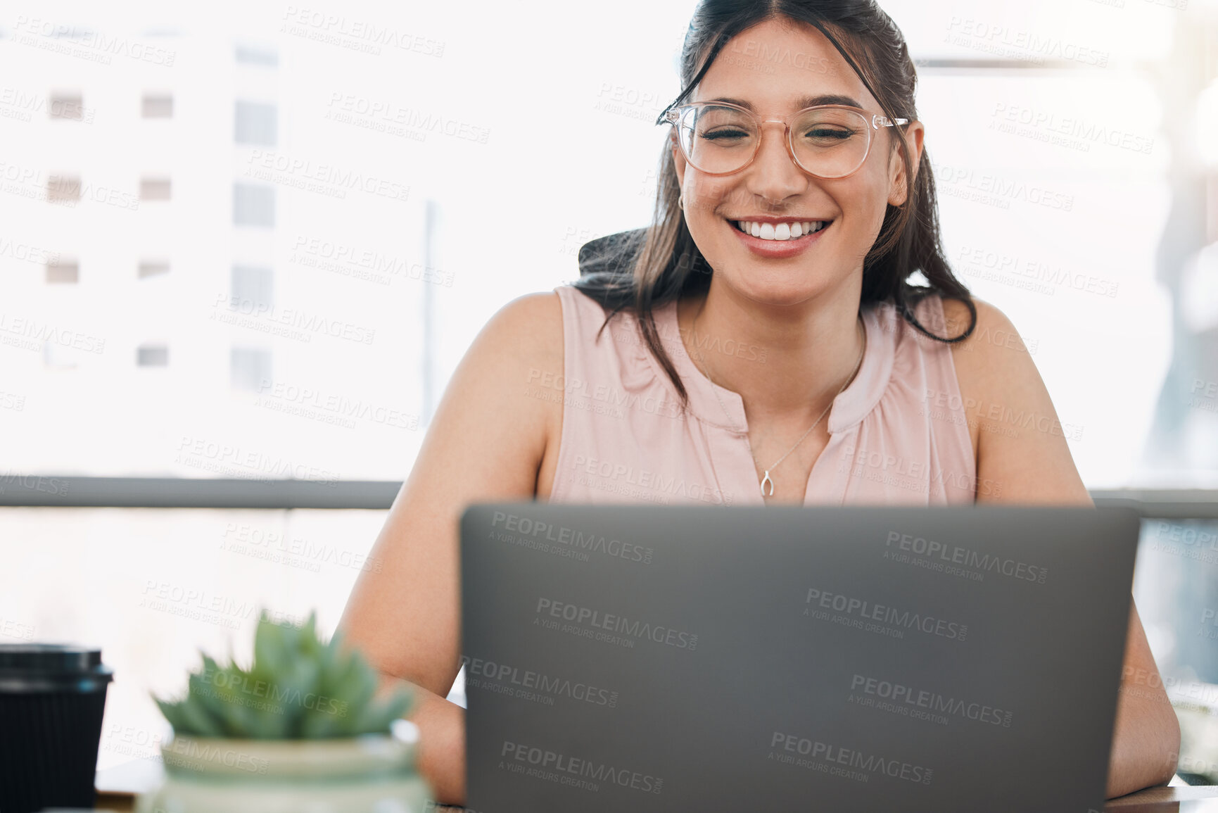 Buy stock photo Shot of an attractive young businesswoman sitting alone in the office and using her laptop