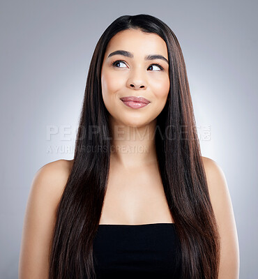 Buy stock photo Studio shot of an attractive young woman looking thoughtful while posing against a grey background