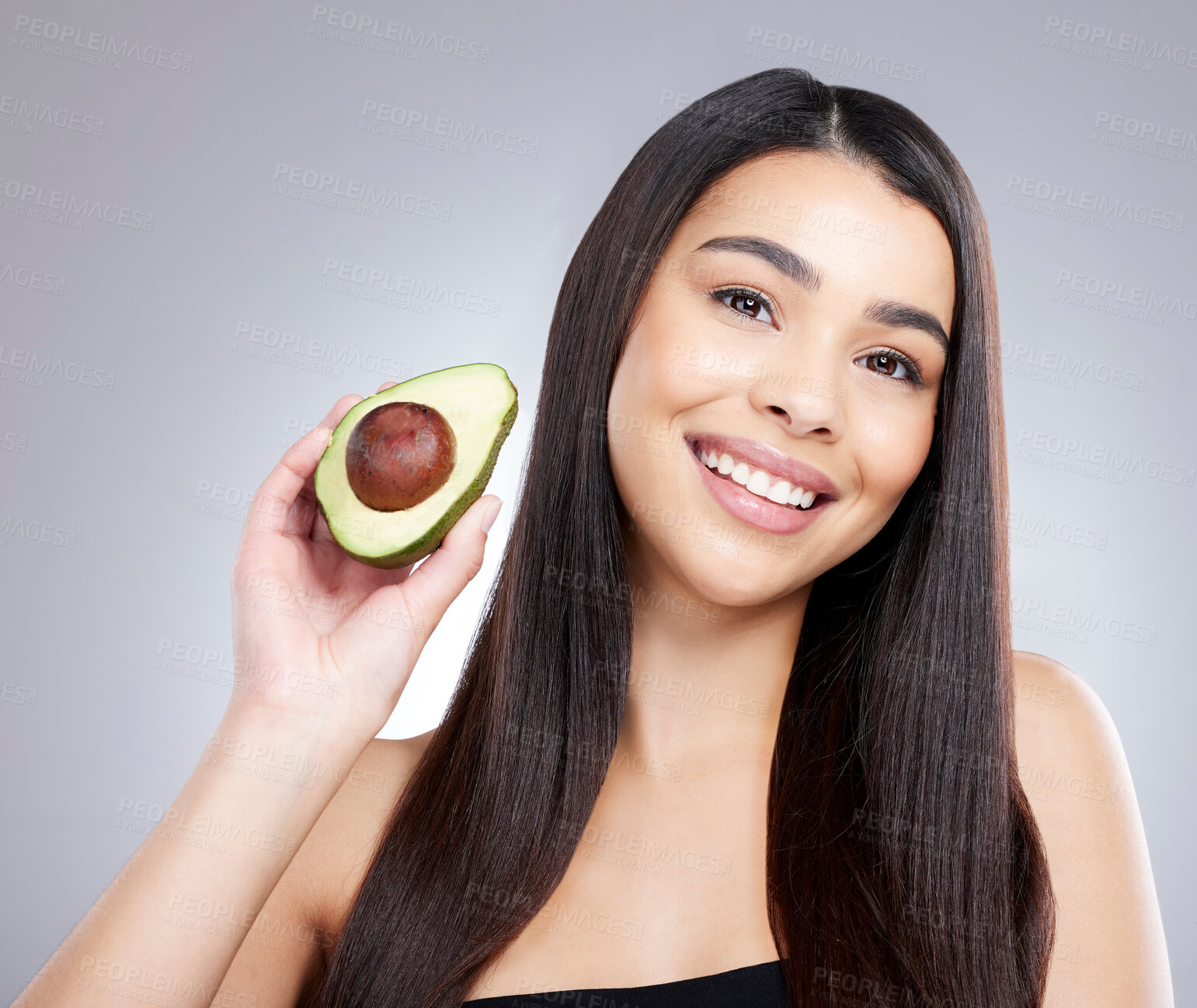 Buy stock photo Woman, portrait and smile with avocado for hair care or organic, natural and omega 3 for treatment or hydration. Girl, fruit and vitamin e for healthy oil or growth, repair and grey background.