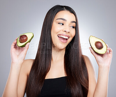 Buy stock photo Studio shot of an attractive young woman posing with an avocado against a grey background