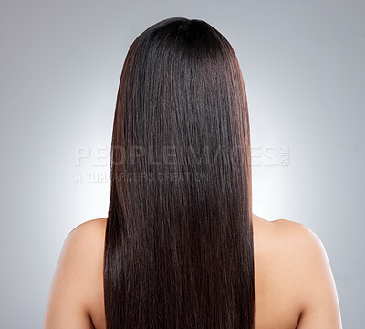 Buy stock photo Rearview shot of a young woman with long silky hair posing against a grey background