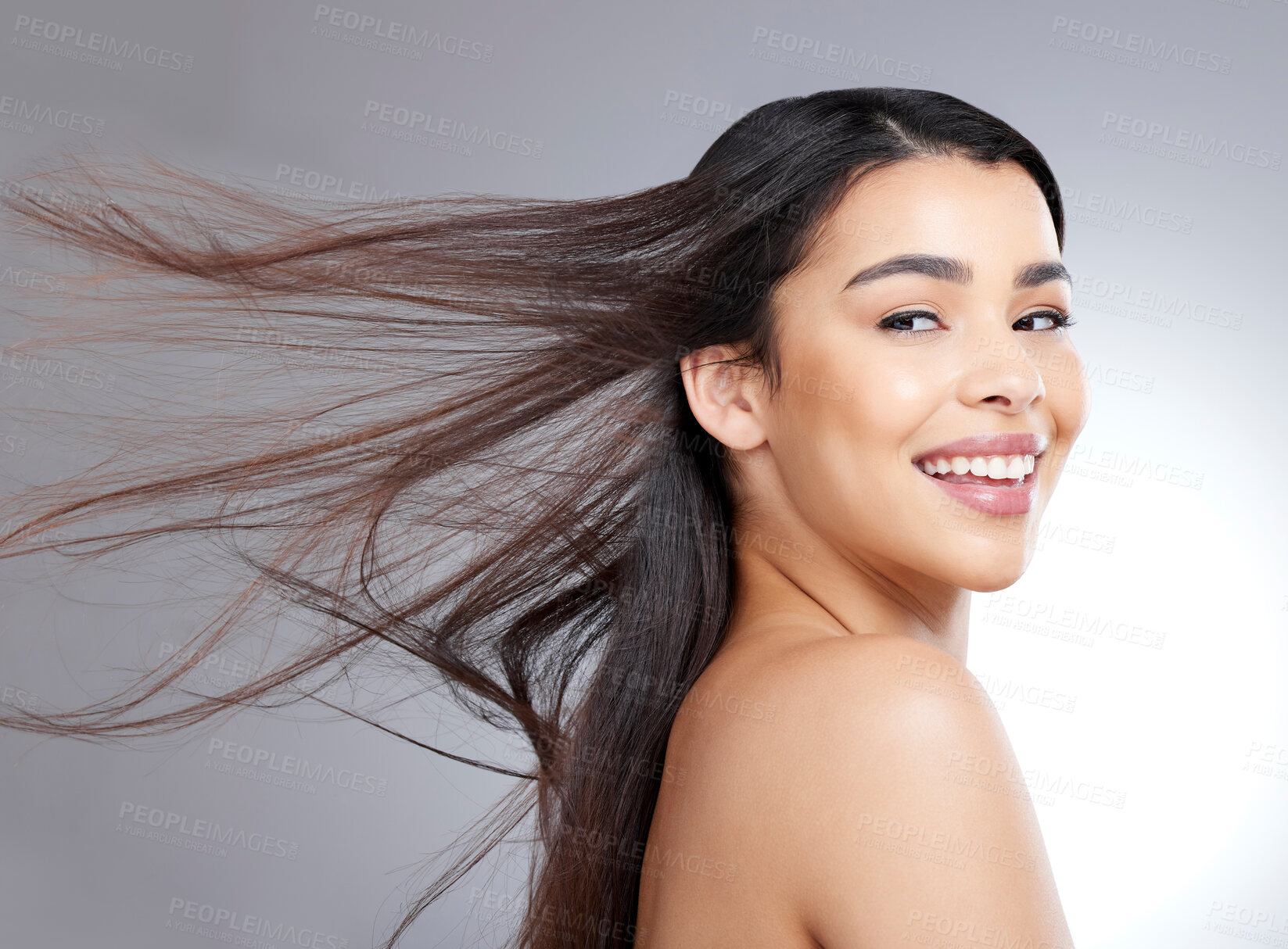 Buy stock photo Girl, smile and thinking in studio for hair care with wind, natural makeup and organic cosmetics for healthy growth. Woman, straight and salon repair on grey background, isolated and keratin.