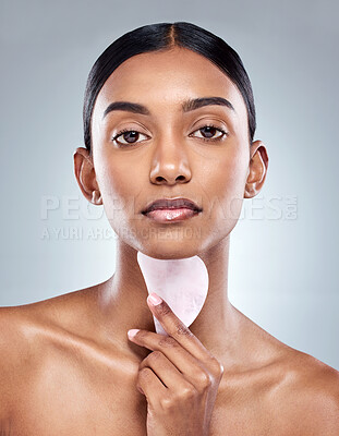Buy stock photo Beauty, skincare and gua sha with portrait of woman in studio for massage, wellness or cosmetics. Spa, self care and glow with model on grey background for facial, cosmetology and rose quartz crystal