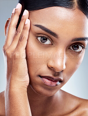 Buy stock photo Cropped portrait of an attractive young woman posing in studio against a grey background