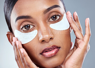 Buy stock photo Skincare, portrait and Indian woman with eye mask in studio for beauty, dermatology and hydration cosmetics on grey background. Wellness, face or model with collagen patch for anti aging treatment