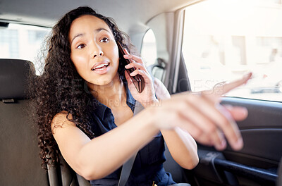 Buy stock photo Shot of a young businesswoman talking on a cellphone while travelling in a car