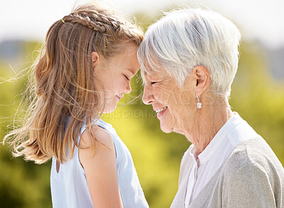 Buy stock photo Shot of an elderly woman spending time outdoors with her granddaughter