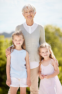 Buy stock photo Shot of an elderly woman spending time outdoors with her granddaughters