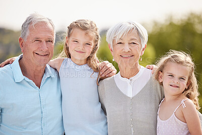 Buy stock photo Shot of an affectionate mature couple and their granddaughters in a park
