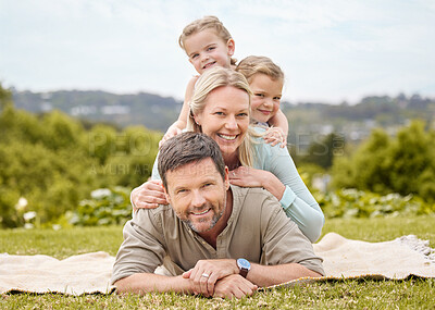 Buy stock photo Shot of a family laying on the floor in a park