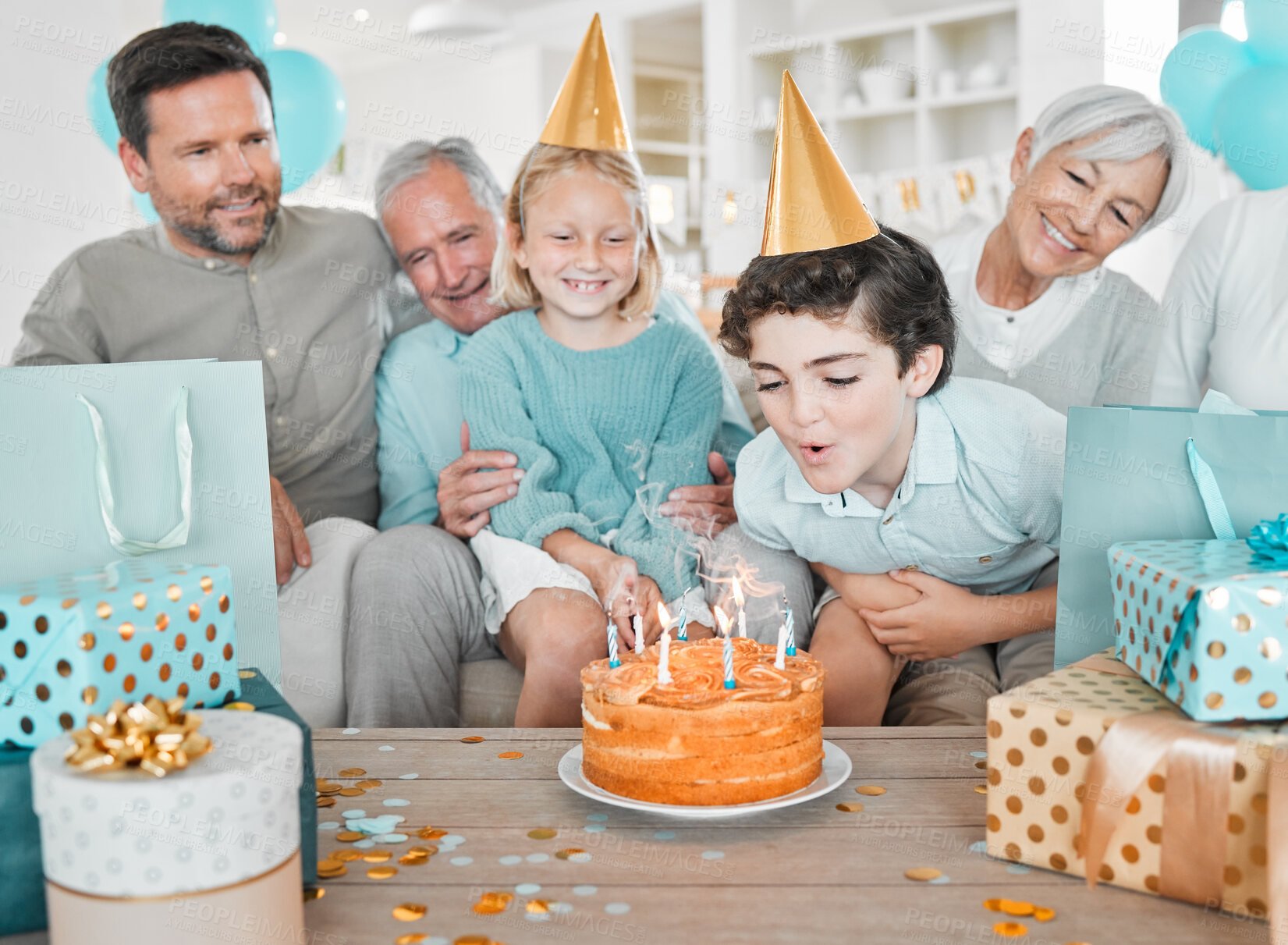 Buy stock photo Boy, birthday cake and blow candles with family in home, cheers and excited with wish for present. Child, parents and grandparents with sister, dessert and tradition with care on sofa in living room