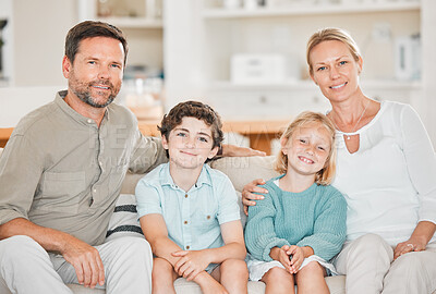 Buy stock photo Cropped portrait of a happy young family of four sitting on the sofa at home
