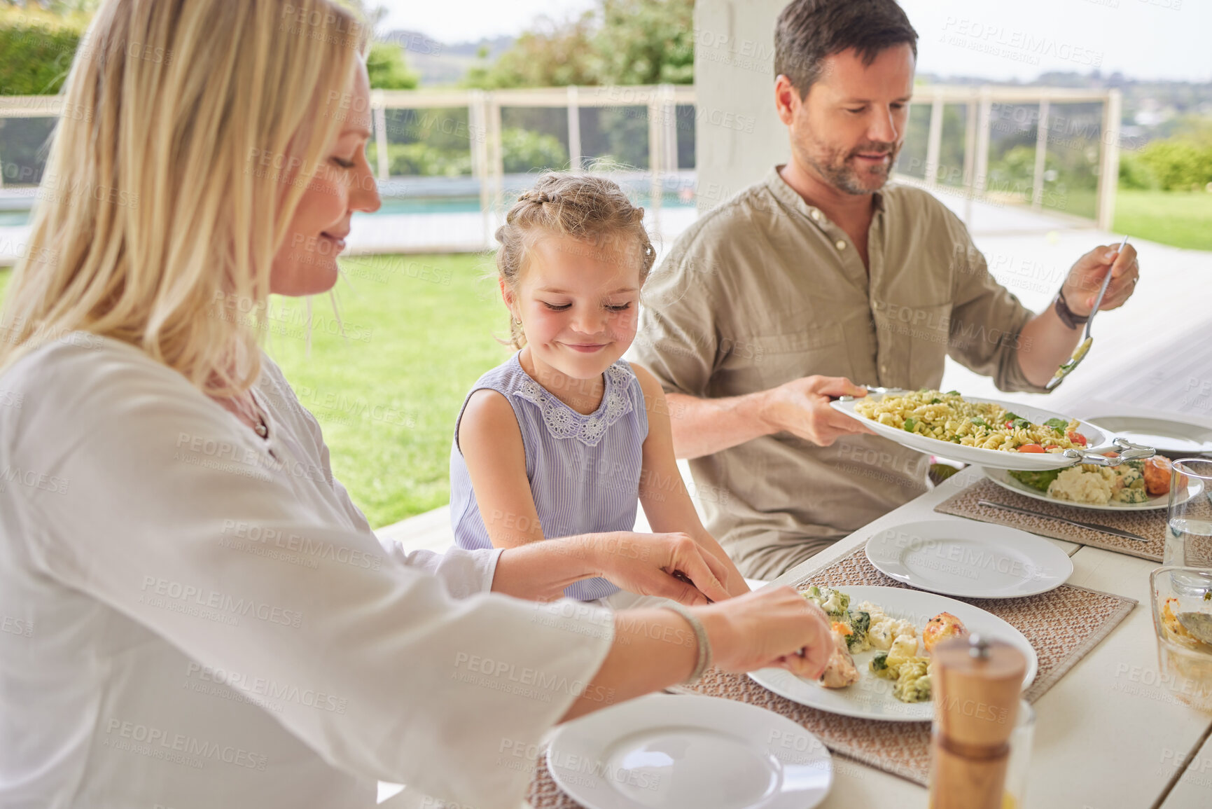 Buy stock photo Family, lunch and mother serving food to child in backyard patio outdoor for thanksgiving celebration at home. Father, mom and kid eating meal at gathering on festive holiday for nutrition or health