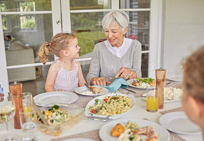 Buy stock photo Shot of a little girl talking to her grandmother during sunday lunch