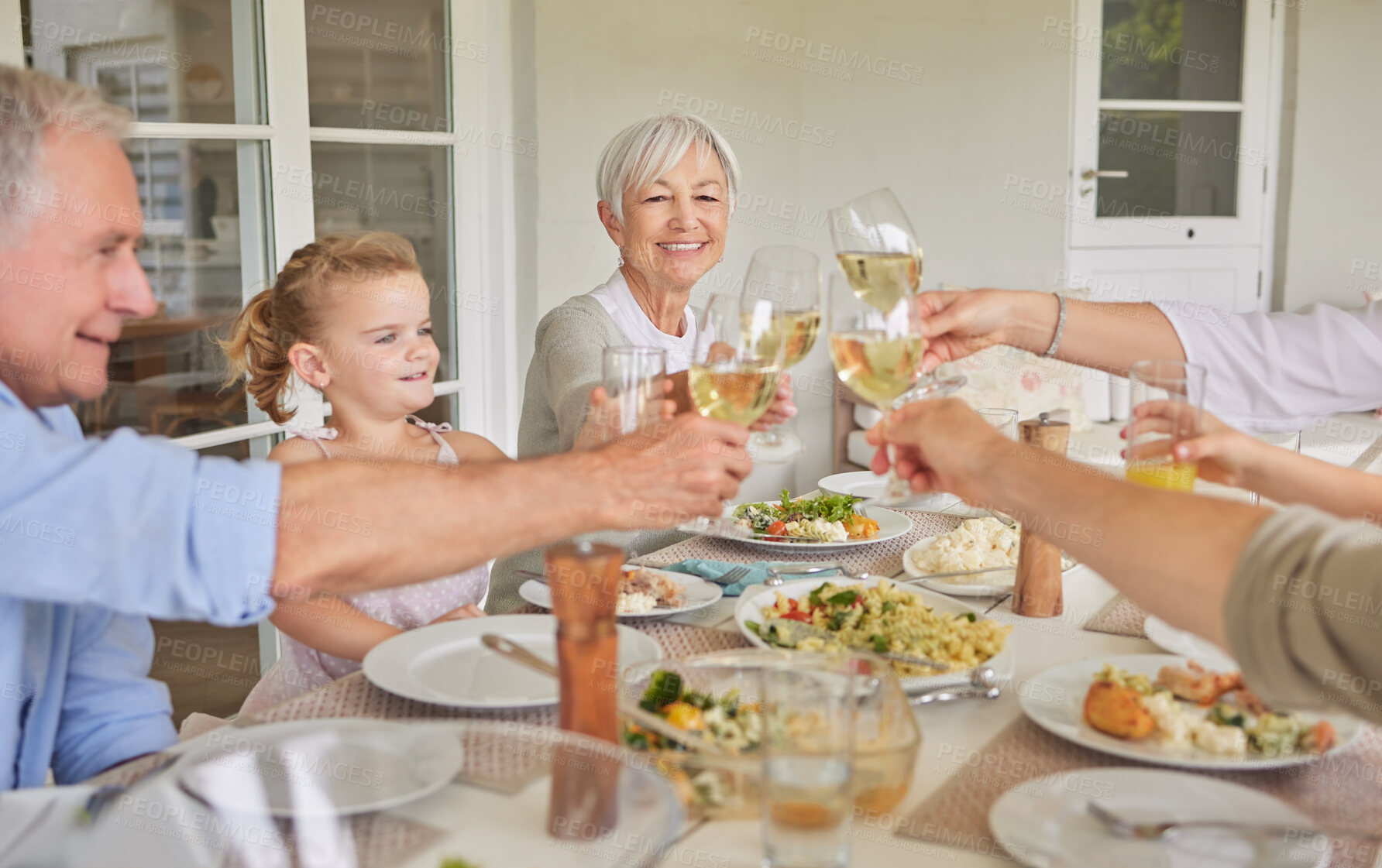 Buy stock photo Happy family, lunch and cheers with wine glass in home patio for thanksgiving celebration. Parents, grandparents and children toast with drinks, food and generations at social gathering on holiday