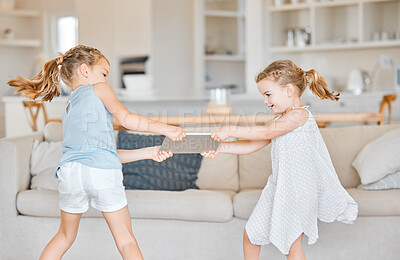 Buy stock photo Shot of two little sisters fighting over a digital tablet at home