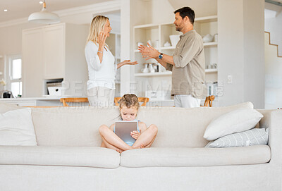 Buy stock photo Shot of a little girl using a digital tablet while her parents argue at home