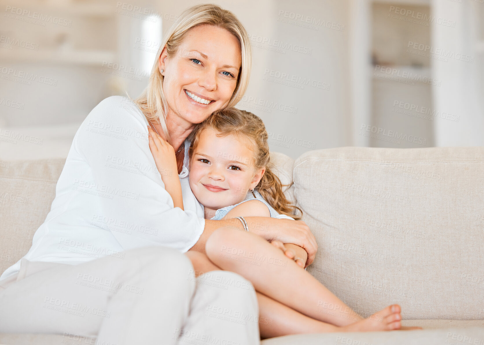 Buy stock photo Mother, happy and daughter for hug, bonding and love in home with support, care and trust on sofa. Family, girl and woman on couch in living room for embrace, relax and smile on weekend with comfort