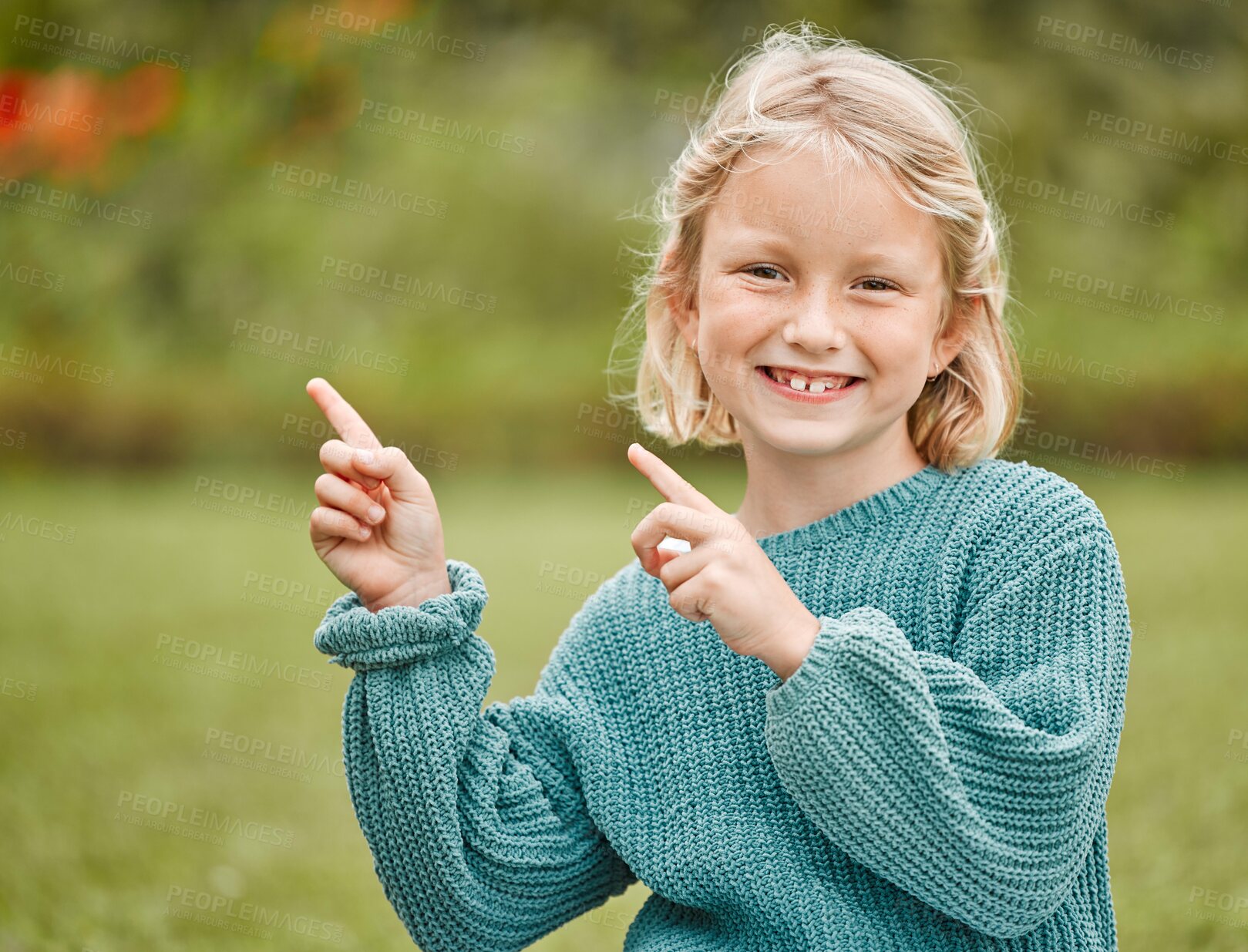 Buy stock photo Happy girl, portrait or pointing with fingers at park for holiday, weekend or outdoor vacation. Young, female person or child with smile or gesture for fun direction or location in nature or backyard