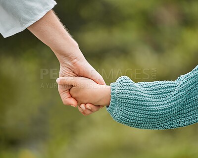 Buy stock photo Cropped shot of a woman holding her daughter's hand while walking outside