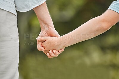 Buy stock photo Cropped shot of a woman holding her daughter's hand while walking outside