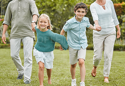 Buy stock photo Shot of a little girl and boy running while outside with their parents