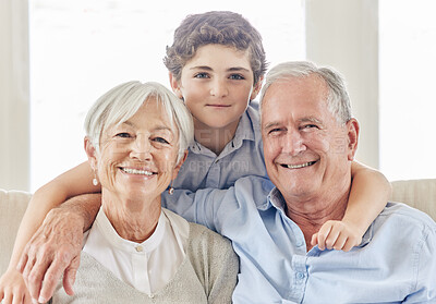 Buy stock photo Shot of a mature couple bonding with their grandson on the sofa at home