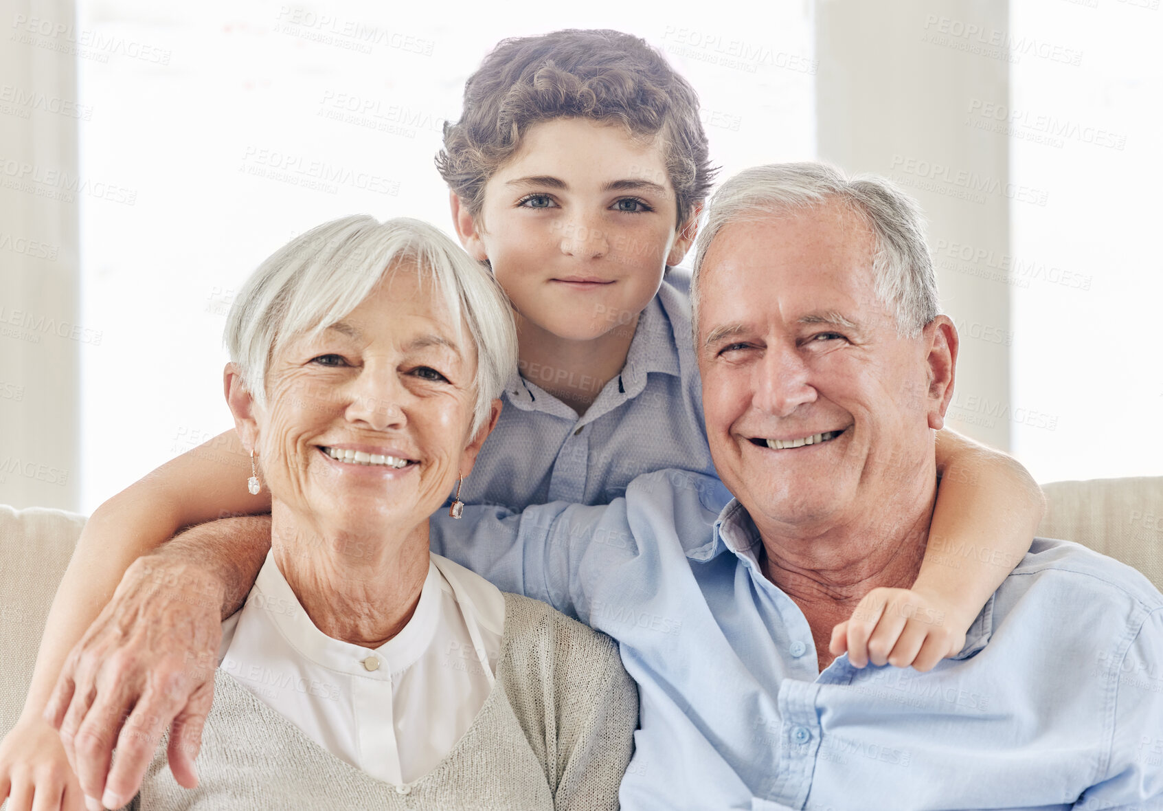 Buy stock photo Shot of a mature couple bonding with their grandson on the sofa at home