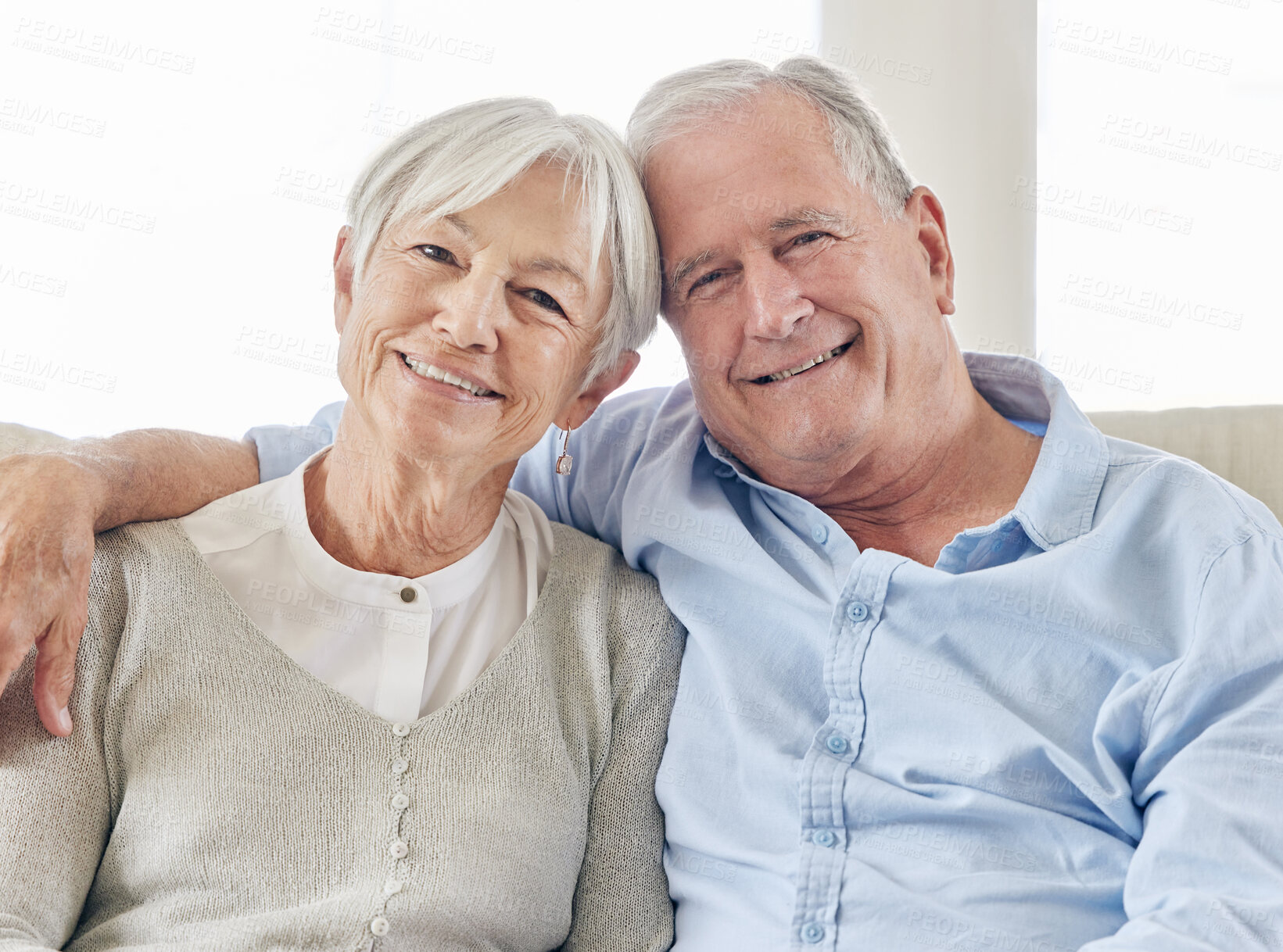 Buy stock photo Shot of a mature couple being affectionate on the sofa at home