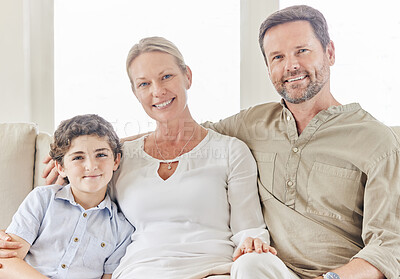 Buy stock photo Shot of a young couple bonding with their son on the sofa at home