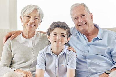 Buy stock photo Shot of a mature couple bonding with their grandson on the sofa at home