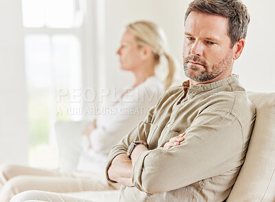 Buy stock photo Shot of a young couple looking annoyed after a disagreement on the sofa at home
