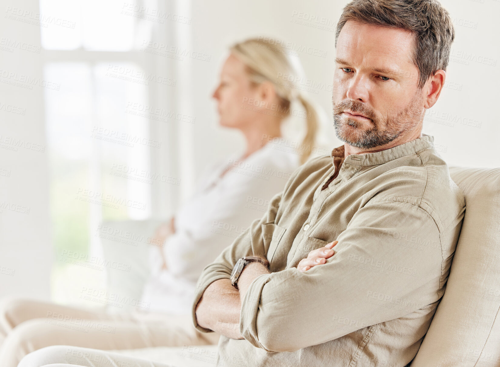 Buy stock photo Shot of a young couple looking annoyed after a disagreement on the sofa at home