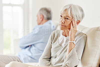 Buy stock photo Shot of a mature couple looking annoyed after a disagreement on the sofa at home