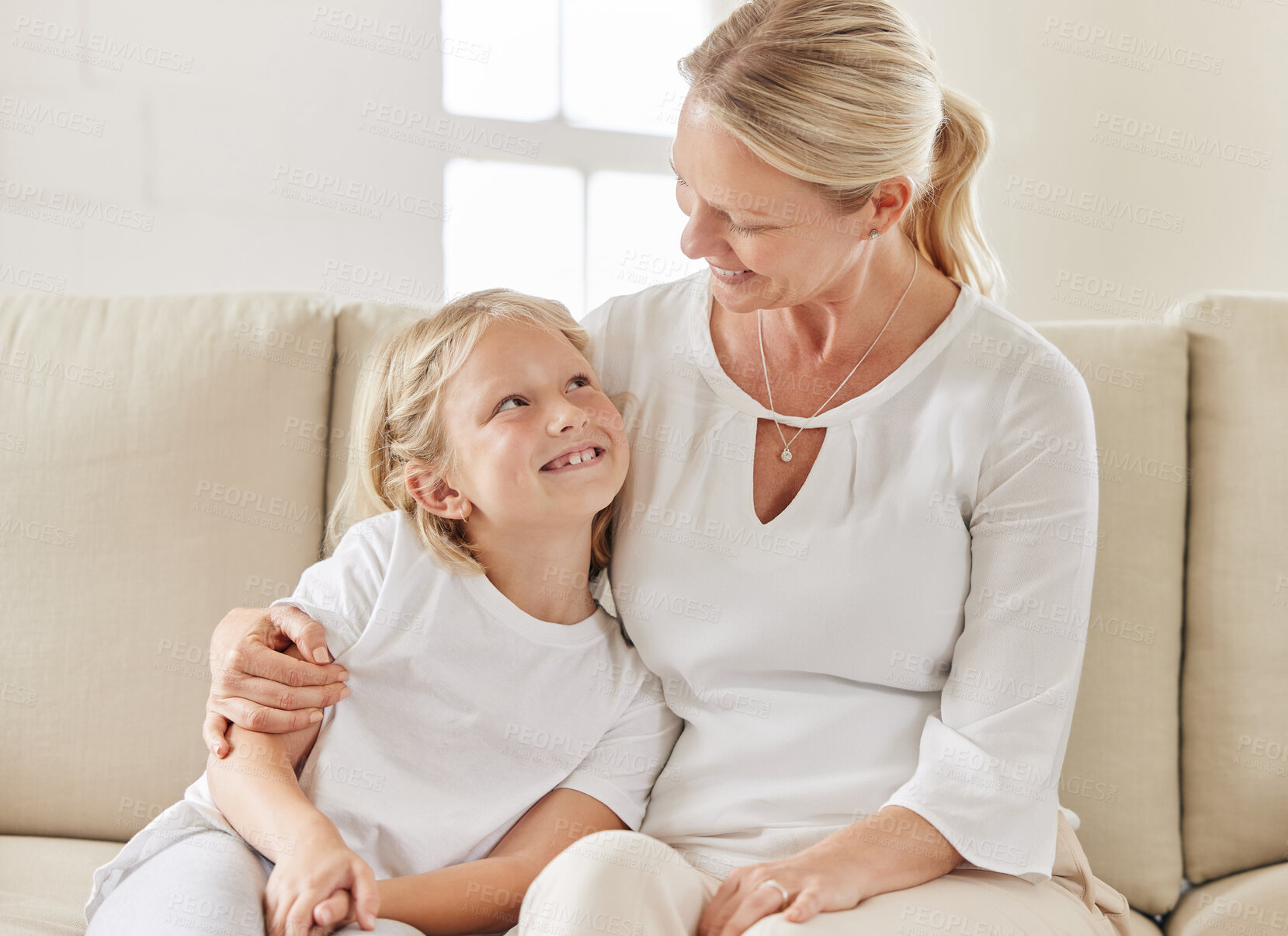 Buy stock photo Mother, daughter and hug in home for safety, love and support child in relationship on couch. Mama, girl and embrace kid for trust on weekend, family house and connection for care in living room