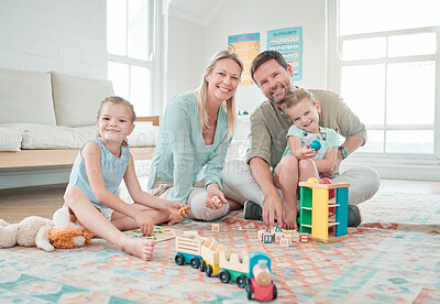 Buy stock photo Shot of two little girls playing with their toys while sitting at home with their parents