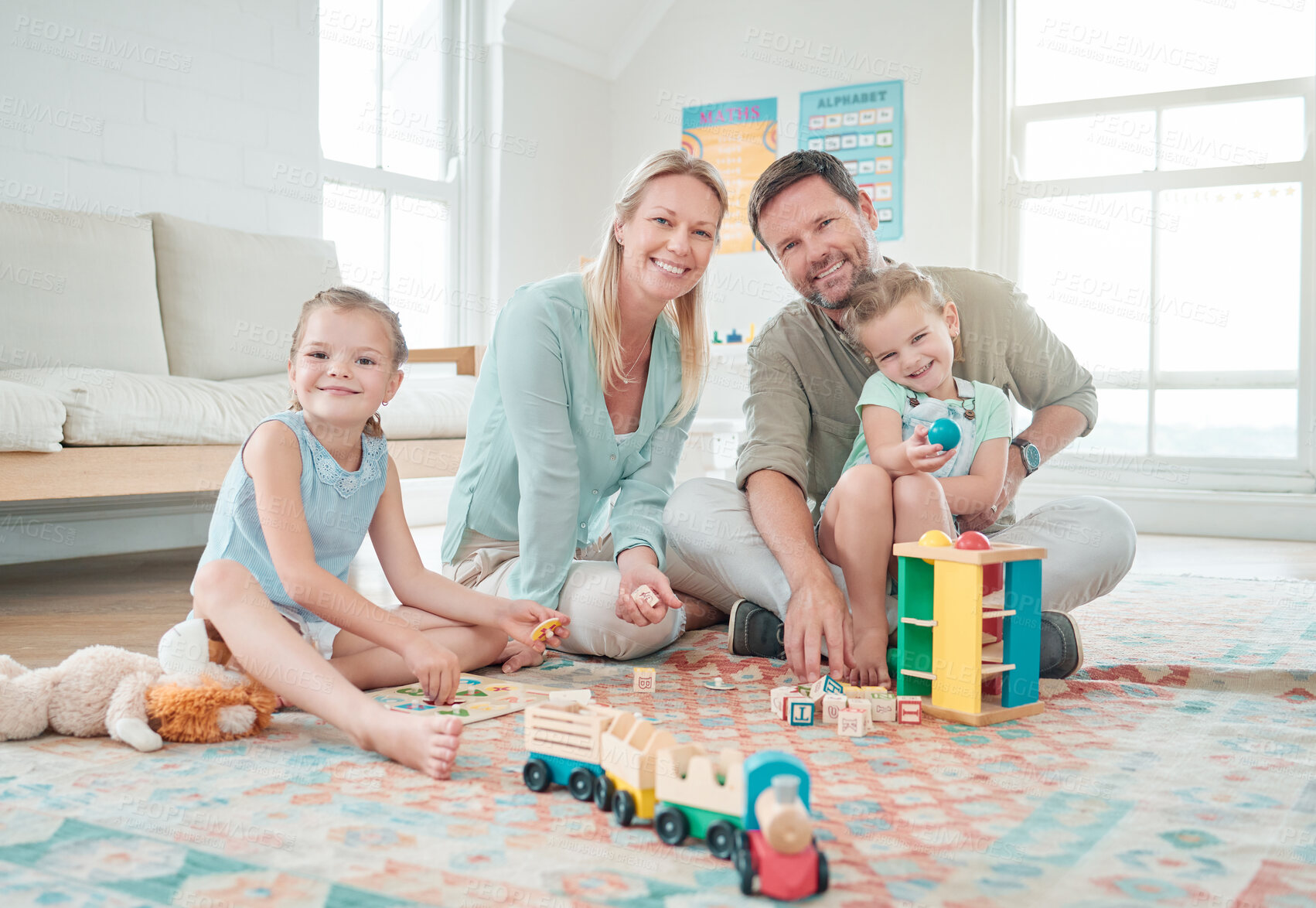 Buy stock photo Shot of two little girls playing with their toys while sitting at home with their parents