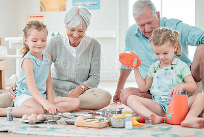 Buy stock photo Shot of two little girls playing with their toys while sitting at home with their grandparents