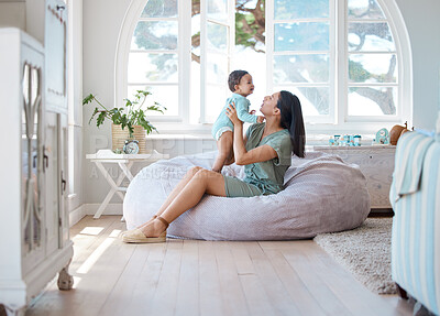Buy stock photo Home, mother and holding baby to relax on bean bag for love, care and quality time together in childhood development. Mom, infant and carrying newborn kid in living room for support, fun and comfort