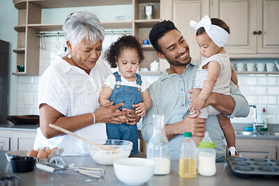 Buy stock photo Shot of a woman baking in the kitchen with her son and two grandchildren