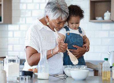 Buy stock photo Shot of a senior woman baking with her granddaughter at home
