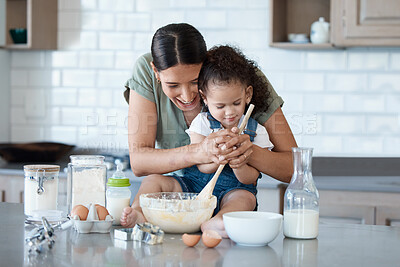 Buy stock photo Shot of a young mom baking with her toddler at home
